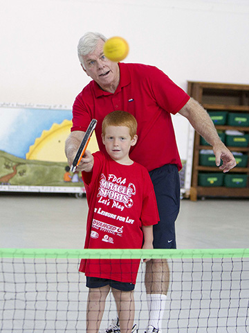 young boy and older man playing tennis