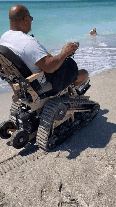 man using an all-terrain mobility device on the beach
